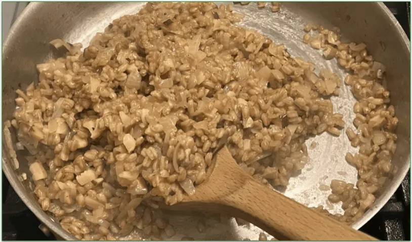 Photo of a risotto being stirred in a pan on the stove