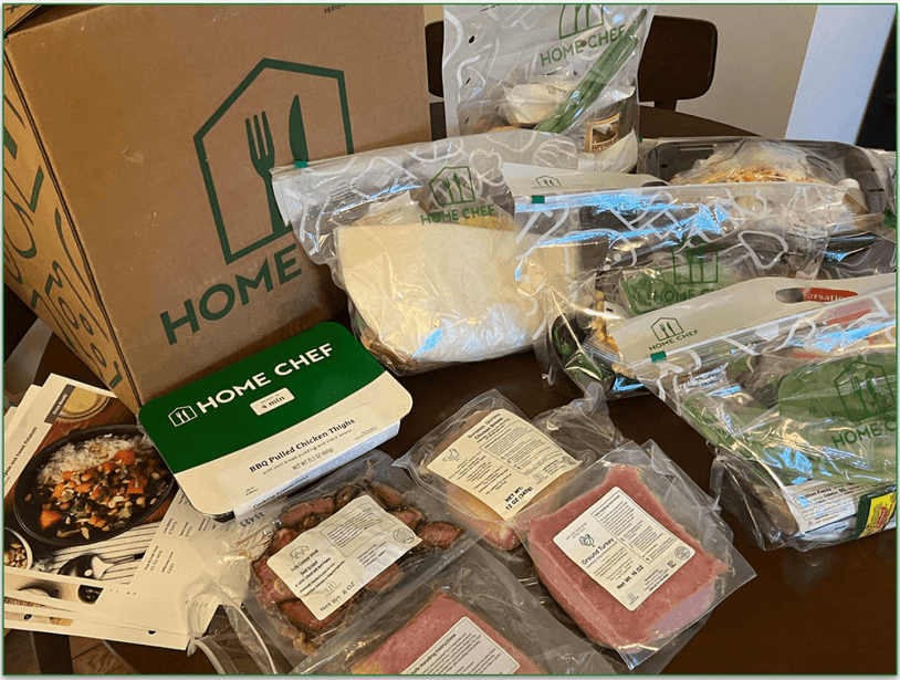 An unboxed Home Chef order showing bags with ingredients sorted by recipe and proteins separately