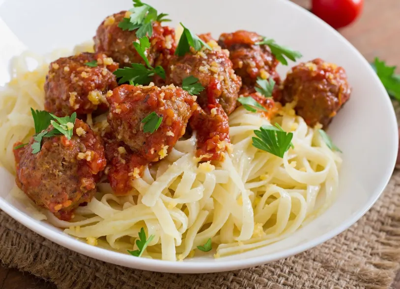 <span>A bowl of spaghetti and vegetable meatballs topped with basil</span><br>
