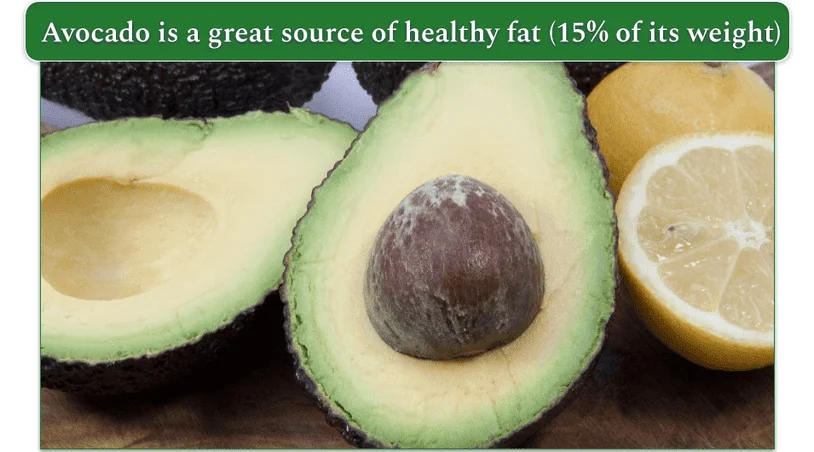 An avocado cut in half accompanied by a lemon, also cut in half.