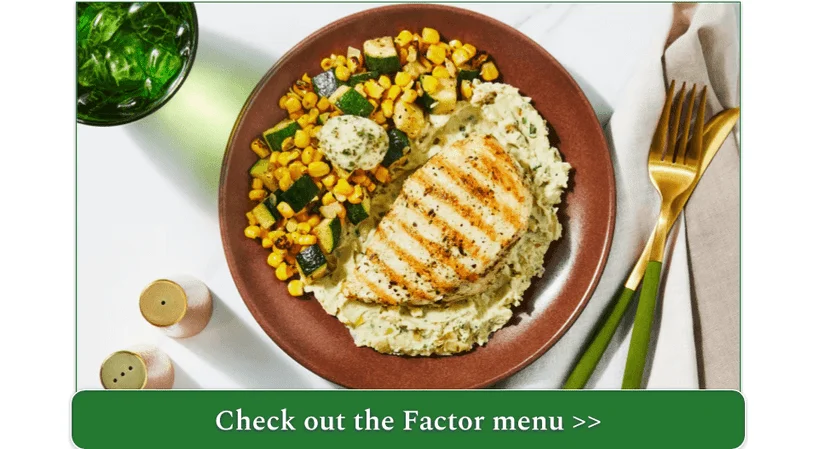 A plate of chicken atop mashed potatoes with a side of carrot and zucchini