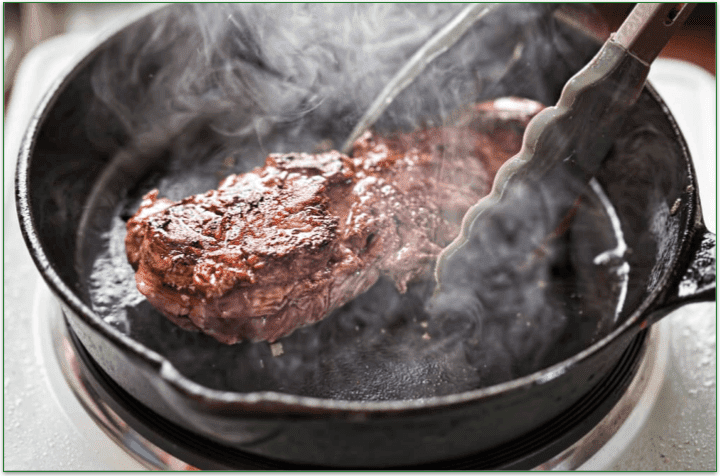 Steak being cooked in a pan