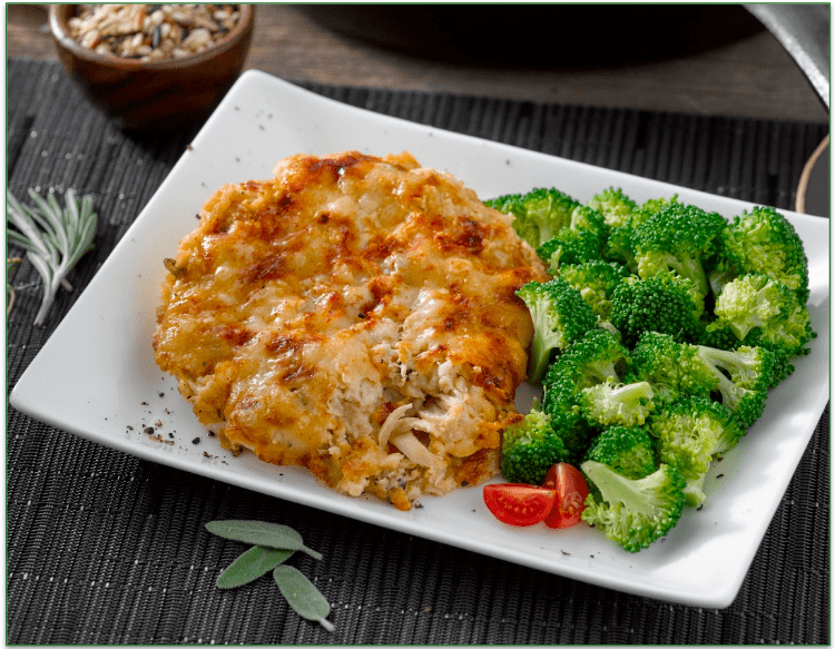 A plate of chicken casserole with a side of steamed broccoli