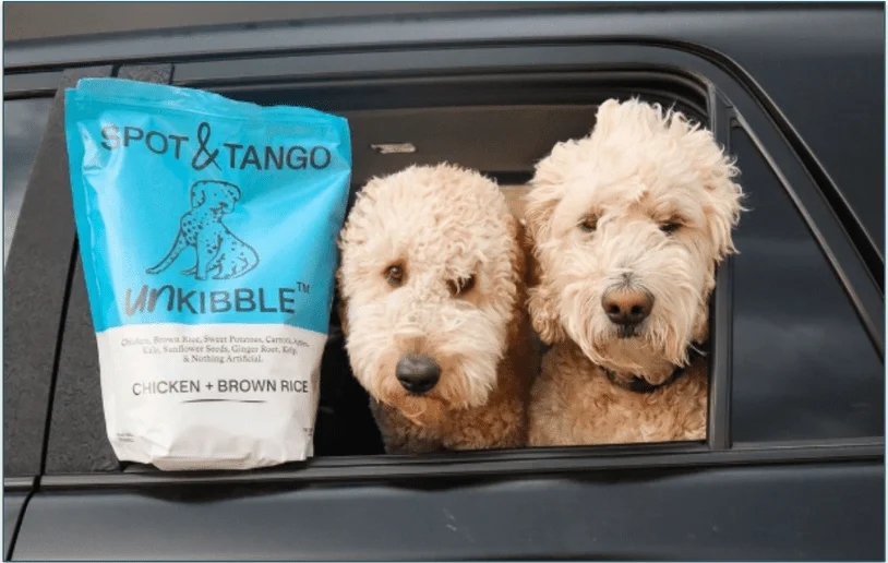 Two dogs next to a Spot & Tango's UnKibble recipe