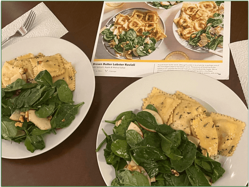 Two plates of brown butter lobster ravioli with the recipe card behind