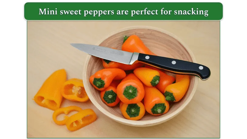 Mini peppers in a bowl with a knife and chopped peppers to the side