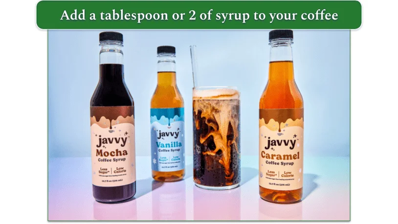 Javvy's 3 syrup bottles next to a glass of coffee with a straw