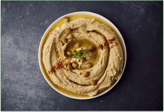 A bowl of hummus on a table.