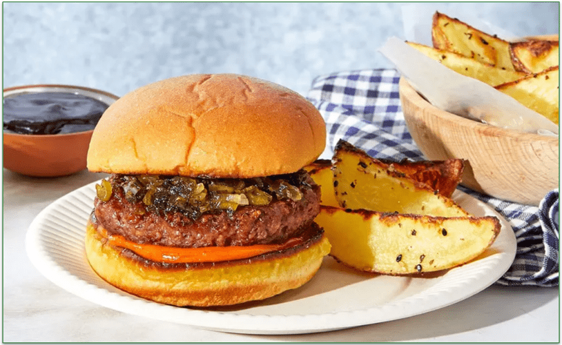 A hamburger on a plate with potato wedges
