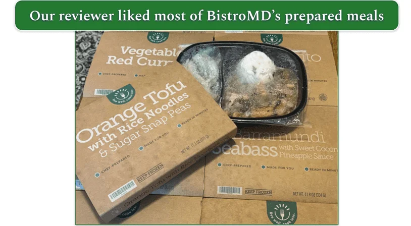 Spread of BistroMD meals in their trays with Orange Tofu on the top