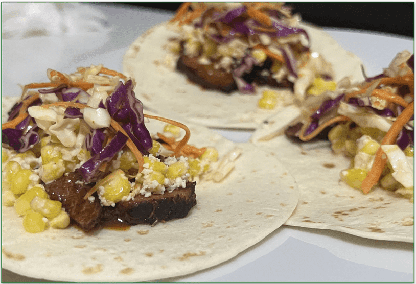 Image of the Spicy Brisket Elotes Tacos served on a plate