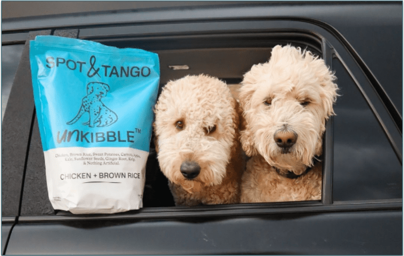 Two dogs next to a Spot & Tango's UnKibble recipe
