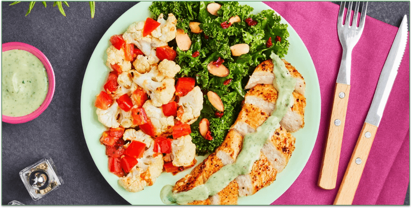 A plate of chicken, cauliflower, and kale salad