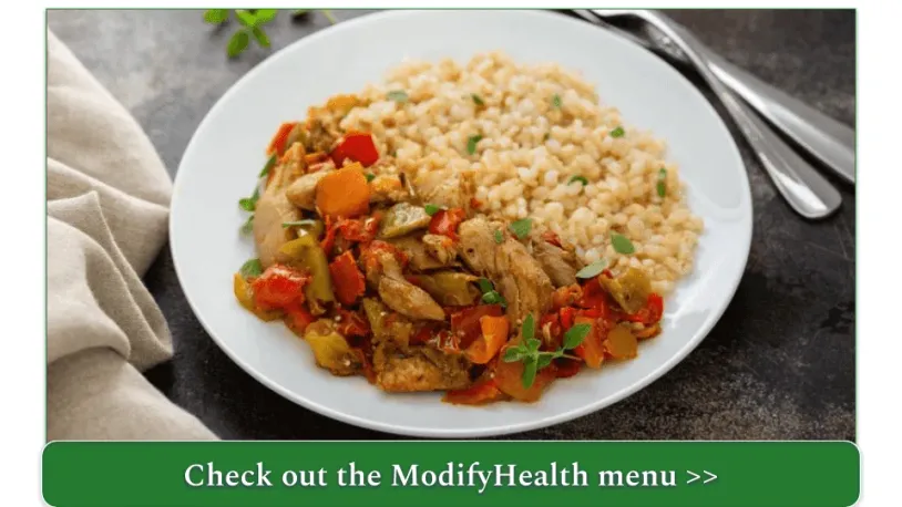 A plate of chicken and vegetables with rice.