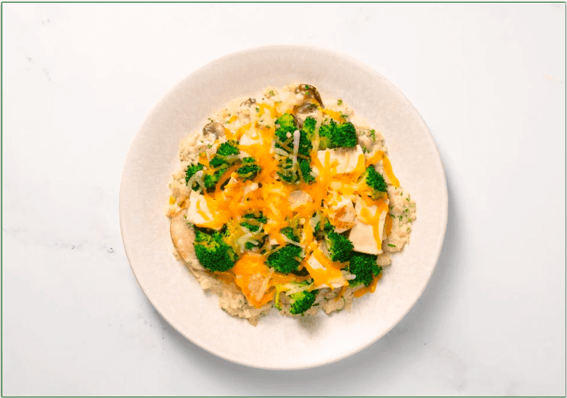 Chicken and broccoli topped with cheddar cheese atop a bed of cauliflower rice