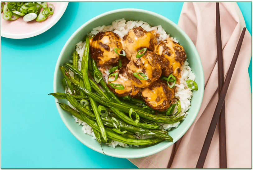 A plate of meatballs and greenbeans over rice