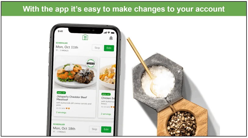 Image of Home Chef's app displayed on a phone screen next to a salt and pepper pot