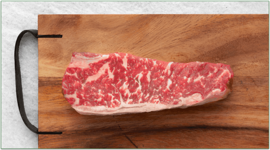 Rastelli's 14 oz Wagyu NY Steak on a wood cutting board.