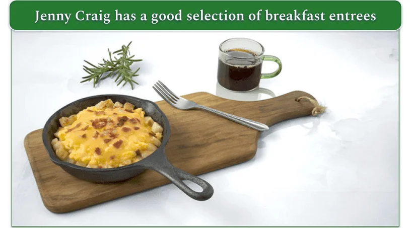 A skillet filled with scrambled eggs, cheese and bacon
