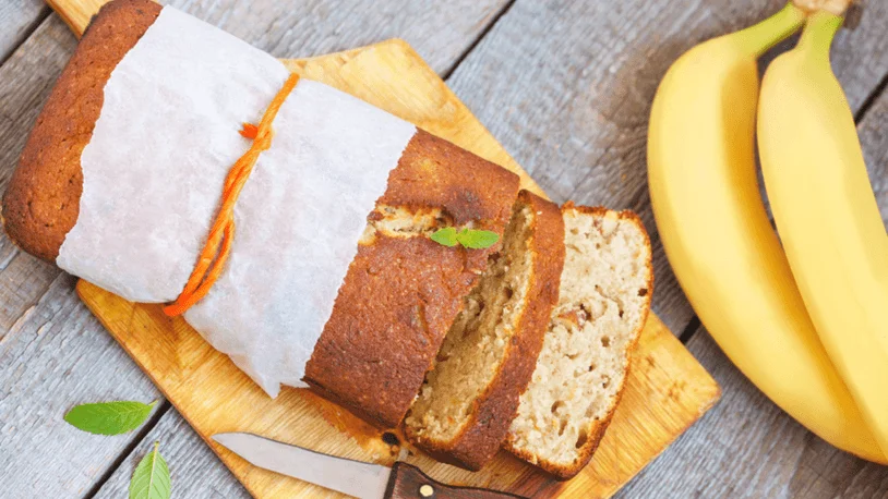 A loaf of banana bread and a bunch of fresh bananas