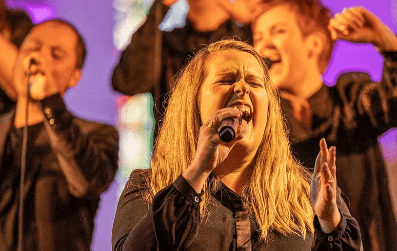 Group of people singing with microphones