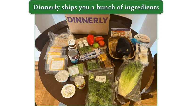 The contents of a Dinnerly shipment, including recipe cards, produce, and packaged proteins