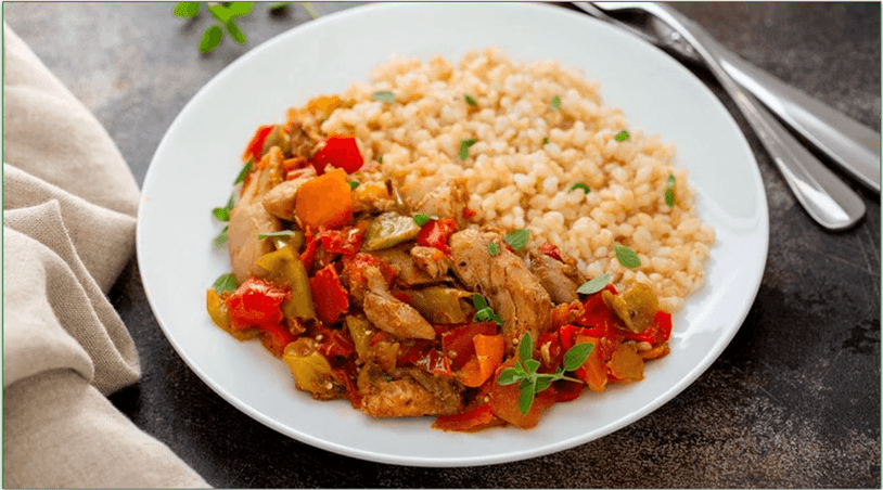 A plate of chicken and vegetables with rice.