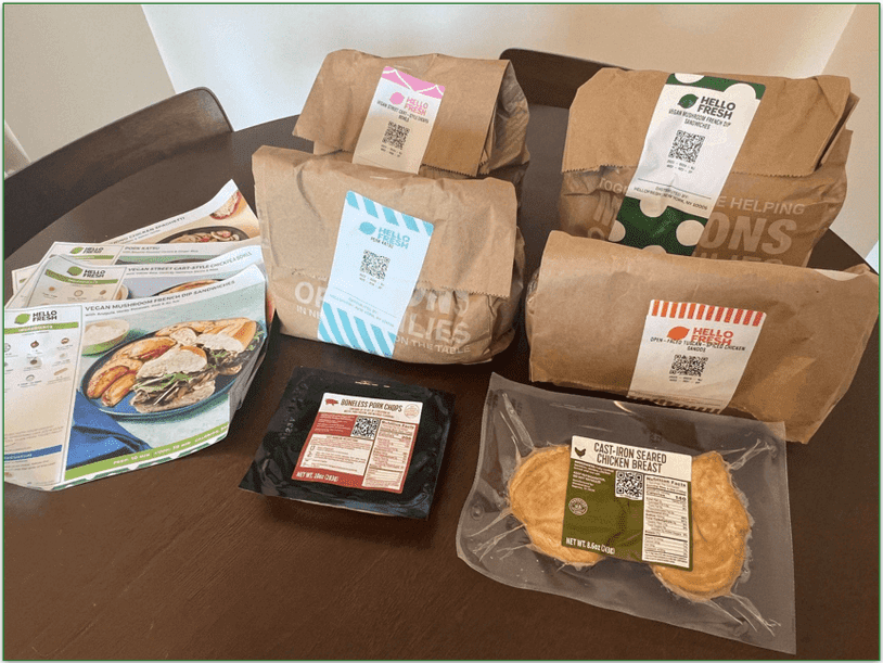 HelloFresh recipe cards and paper bagged ingredients on a table