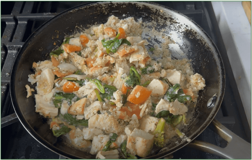 The Greek Lemon Garlic Chicken Quinoa Bowl being heated in a skillet on the stove