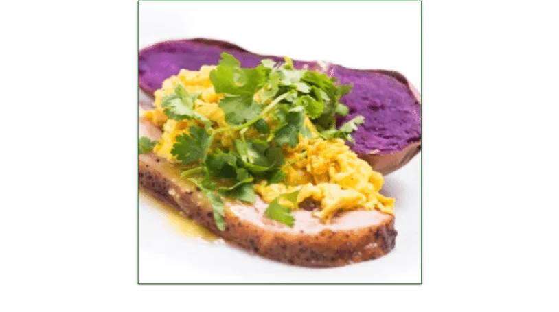 A slice of smoked pork belly topped with eggs and a side of organic purple sweet potato. 