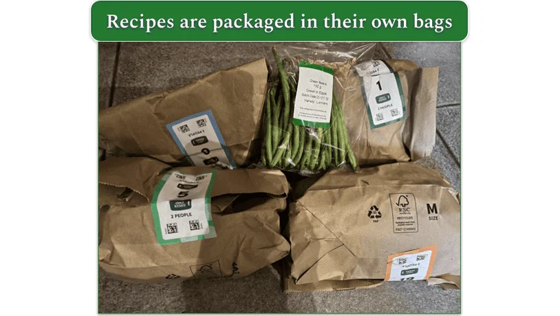 An unboxed Green Chef order showing bags stating the recipe name and number of servings