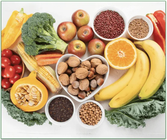 A table featuring various different whole foods like nuts, seeds, fruits, and veggies.