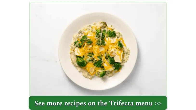 Chicken and broccoli topped with cheddar cheese atop a bed of cauliflower rice