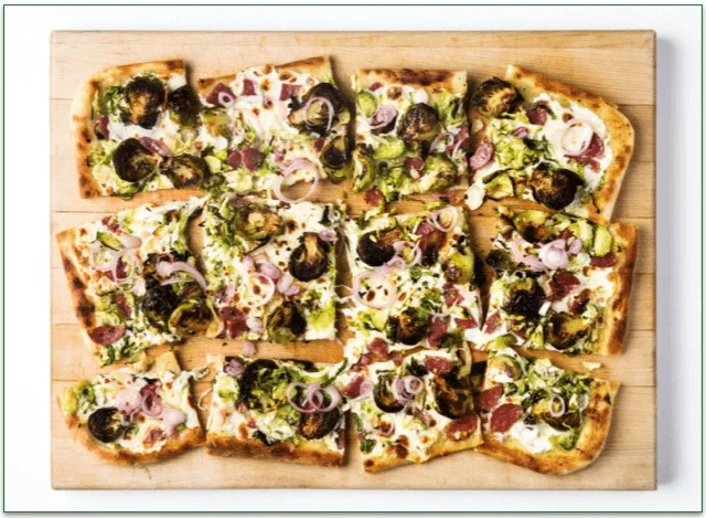 Pizza on a board with slices of salami