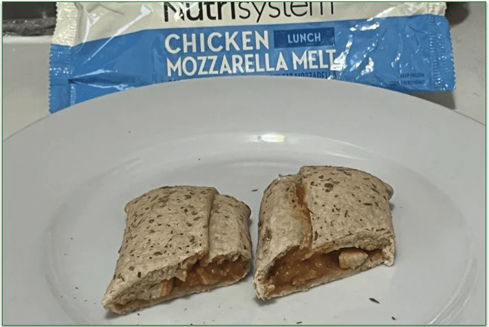 Photo of the Chicken Mozzarella Melt from Nutrisystem served cut in half on a plate in front of the packaging