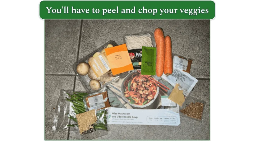 An unboxed Green Chef box showing whole vegetables and other ingredients in individual packets