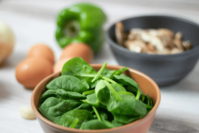 Featured image with a bowl of washed, fresh spinach in the foreground