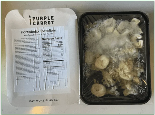 Photo of the Portobello Tortelloni prepared meal in the microwaveable tray next to the cardboard sleeve displaying heating instructions, ingredients, and nutrition details