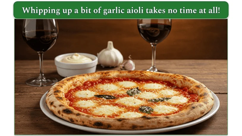 A margarita pizza on a plate beside some garlic aioli alongside 2 glasses of red wine and a bulb of garlic.