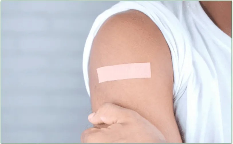 An arm with an adhesive bandage placed on it