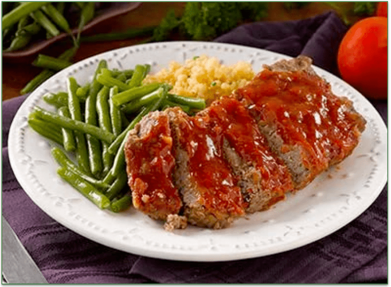 A plate of meatloaf with green beans