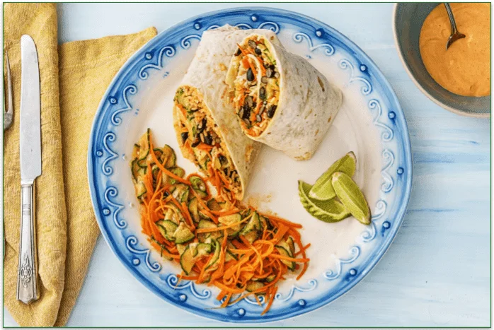 Kimchi hot sauce burritos with black beans, carrots, and pickled cucumbers.