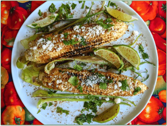 Corn on a plate with cheese and lime