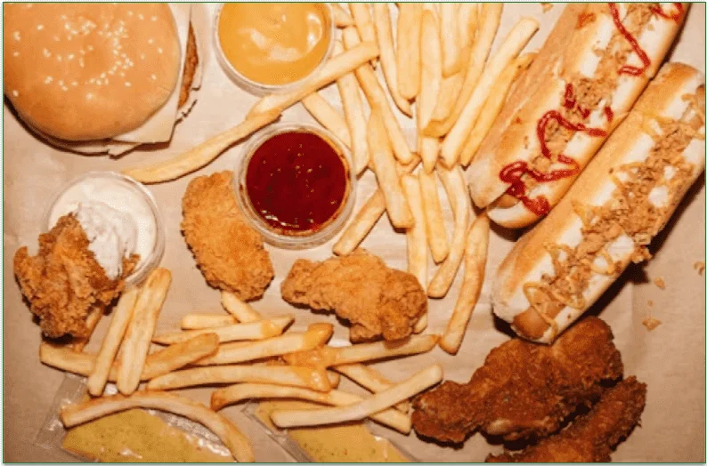 An assortment of processed fast food including hot dogs and fried chicken