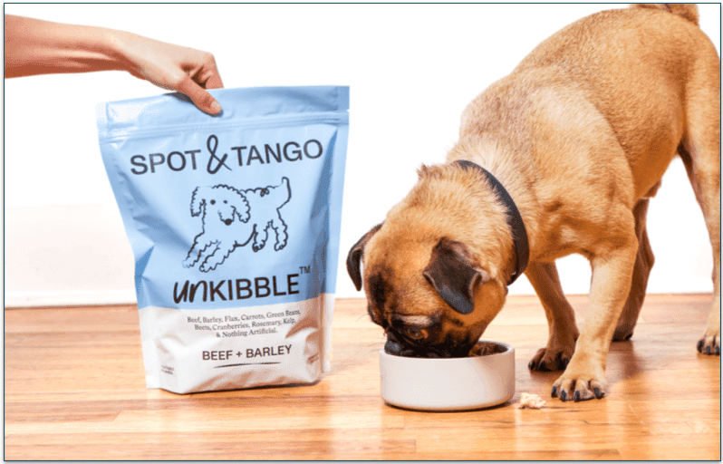 a pug eating from a bowl next to a pack of spot and tango’s unkibble