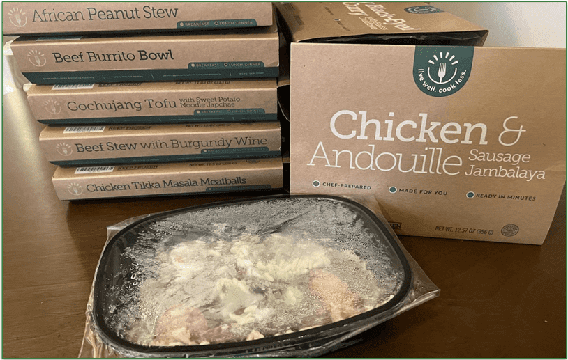 Photo of a stack of BistroMD meals with one meal taken out of the cardboard packaging