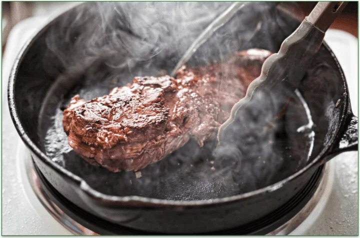 Steak being cooked in a pan