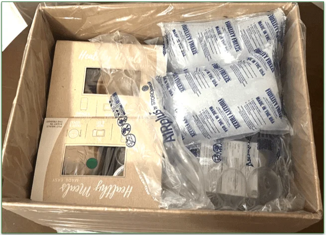 Inside the delivery box meals are stacked with plastic wrapping and ice packs