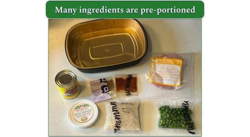 Dinnerly ingredients set out in individual portioned packs, clearly labeled alongside an oven-safe tray