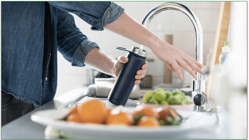 a picture of someone filling up a water bottle